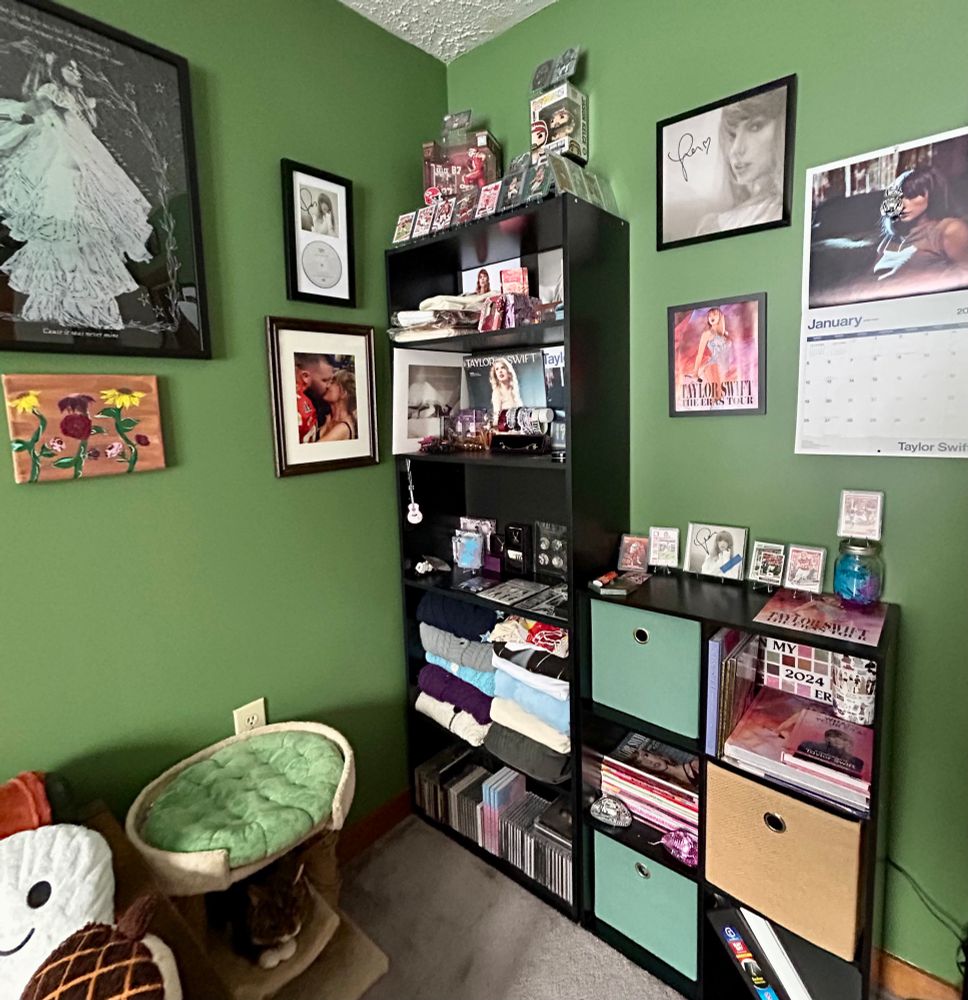 A shelf and wall full of Taylor merch
