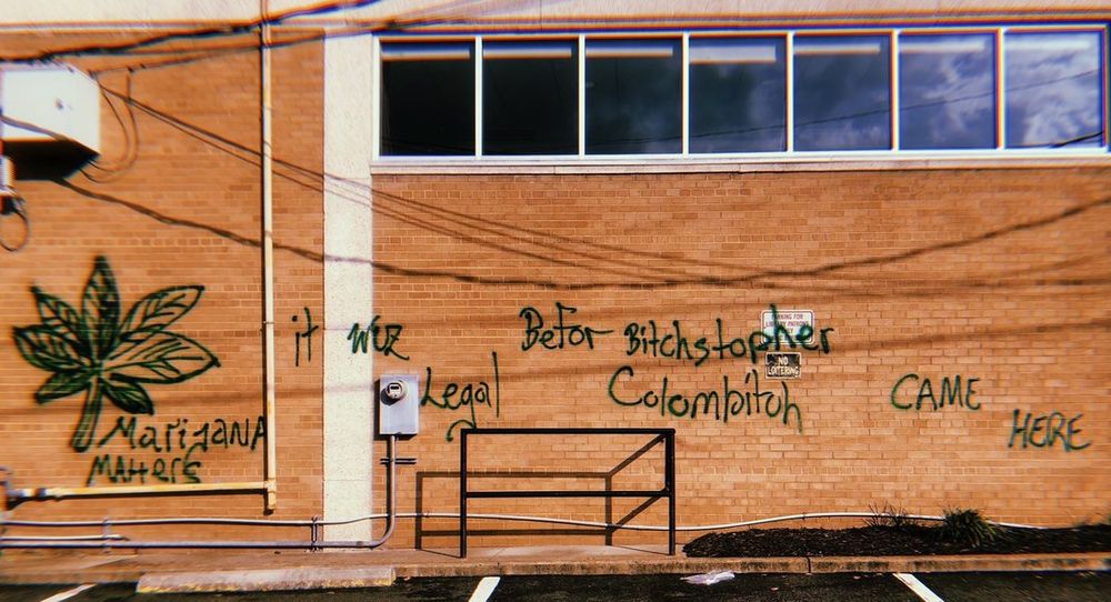 old photo of a wall with graffiti reading: Marijana Matters it wuz Legal befor Bitchstopher Colombitch CAME HERE