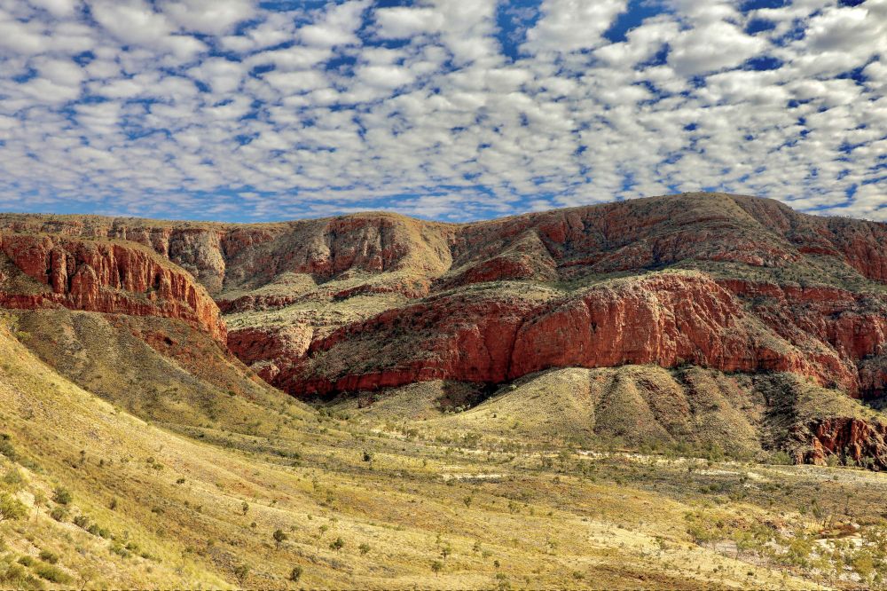 Early afternoon clouds start to come together after a day of floating apart to cast weak shade on the red rocks and ochre land of this incredible pound. 