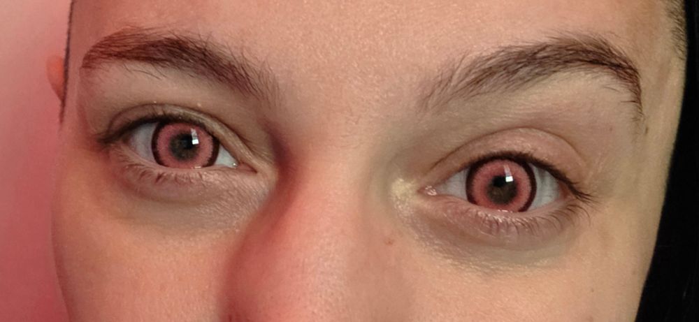 Closeup of C0ffinCunt's eyes with pink contact lenses