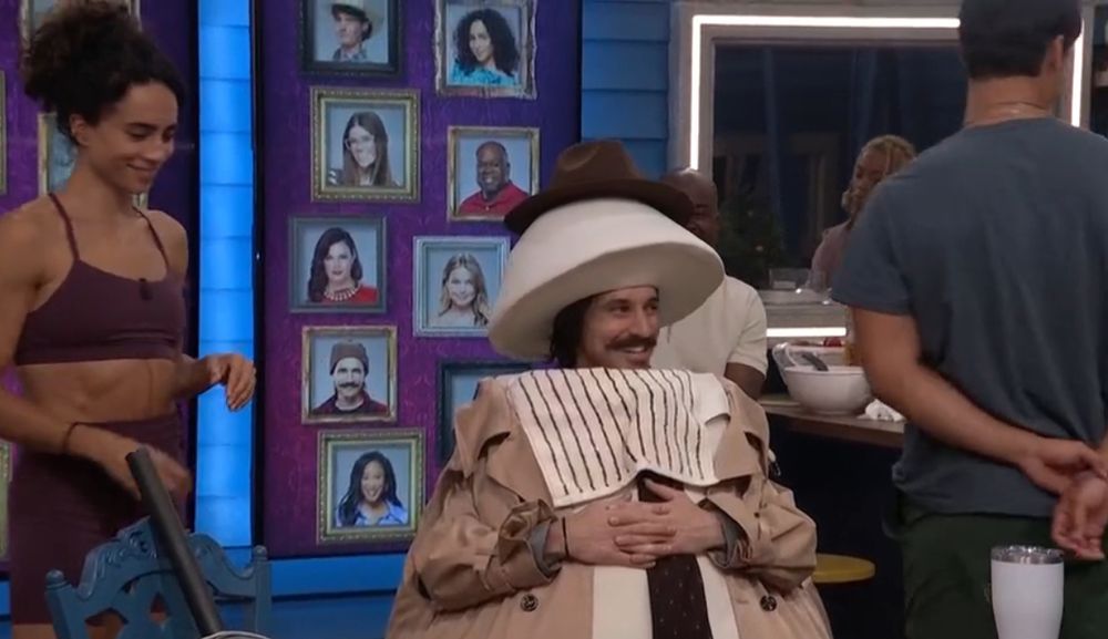 Vince the egg sitting on his egg stool at the kitchen table with a napkin tucked under his chin 