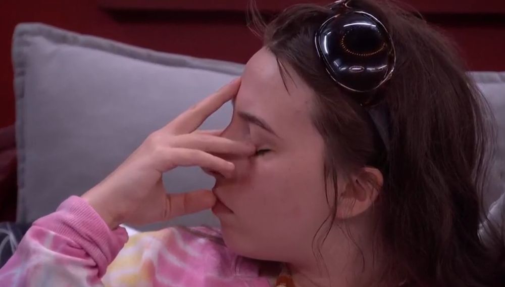 Ava with her eyes closed and her fingers pressed to her face. 