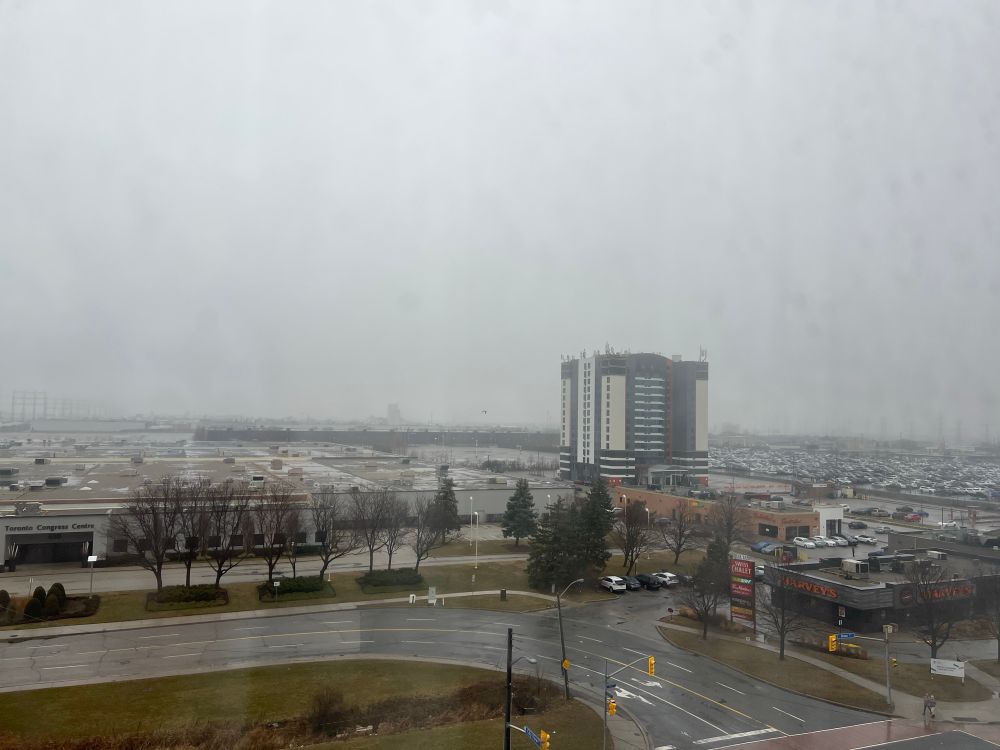 Rainy/gloomy view from a hotel window.
Several buildings in view.