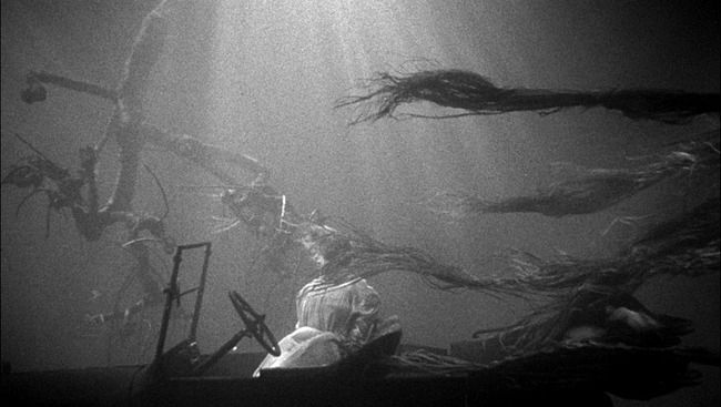 scene from night of the hunter. a very ethereal shot of a woman in a car, underwater, hair flowing