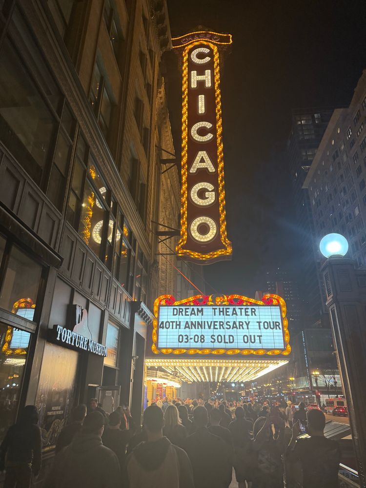 Picture outside of the Chicago theater at night. Text reads: “Chicago” on the iconic sign. The box office text underneath says: “Dream Theater. 40th anniversary tour. Sold out” 
