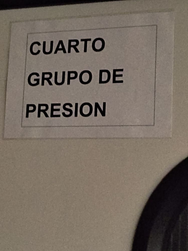 Un cartel de papel en una puerta blanca. Pone "cuarto grupo de presión"