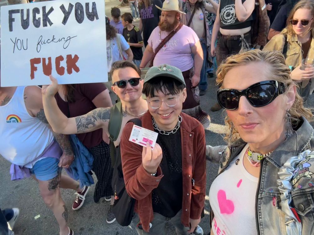 Me holding the invite card I got. Behind me is Nico, holding a sign that says "Fuck you you fucking fuck" (not a reference to the card!).