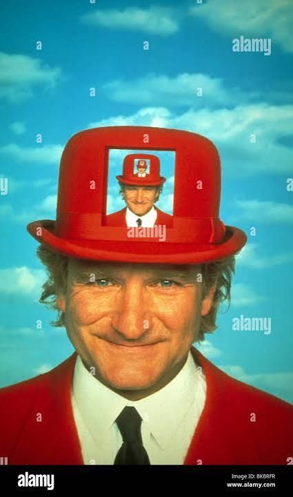 Robin williams dans toys il porte un costume rouge et un chapeau melon rouge portant la même photo 