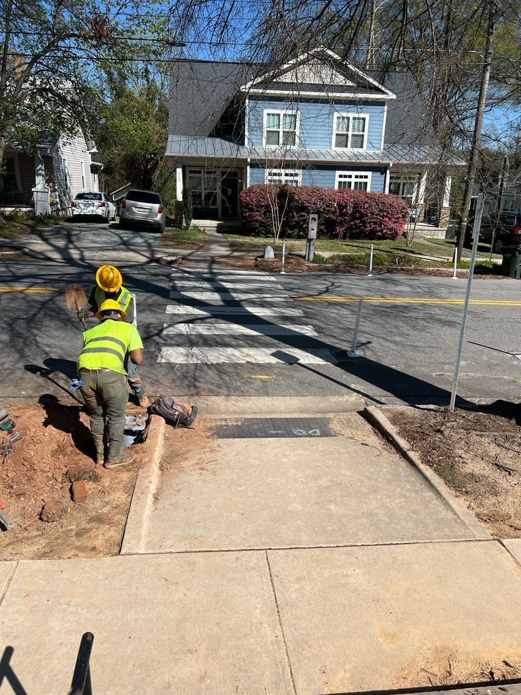 Contractors work on the base for the Rectangular Rapid Flashing Beacon (RRFB) push-button blinky lights. 