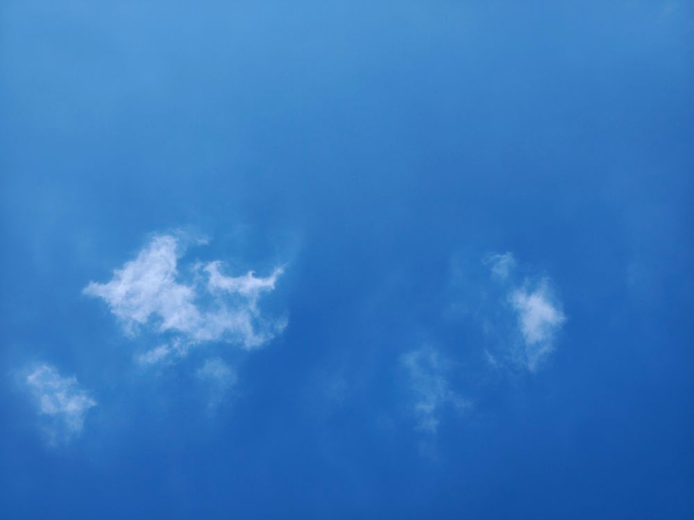 Blue sky above England with small wispy clouds 