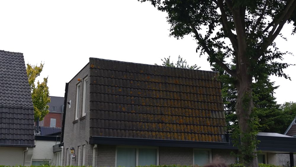 photo of a house that looks awkwardly like the top floor was chopped off due to the style of the shingles