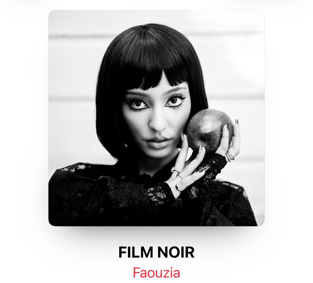 Cover of album by Faouzia called FILM NOIR. The cover shows her in black in white, from shoulders up. Shes wearing a black long sleeve lace top and has a short bob with bangs. She’s staring at the camera and holding an apple, her hands have multiple rings and her nails have polka dots on them. 