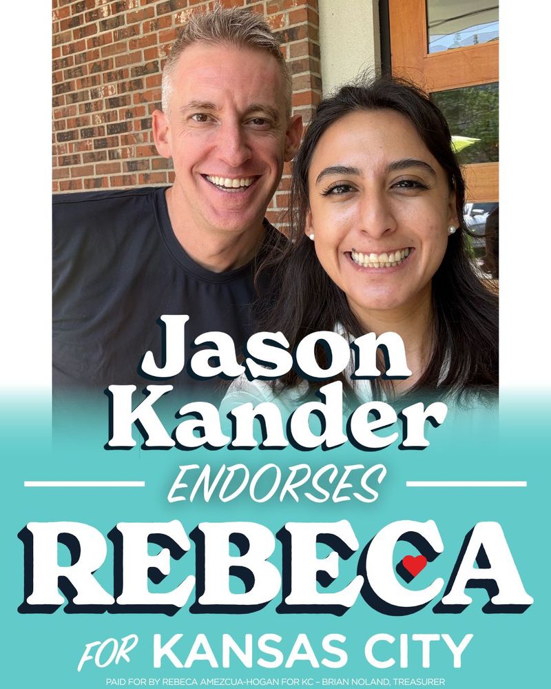 A campaign graphic showing Jason Kander and Rebeca Amezcua-Hogan taking a selfie together in front of a brick wall, smiling. Rebeca's logo has the feel of a hand painted Mexican sign.