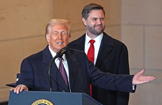 Donald Trump stands at a podium with JD Vance behind 