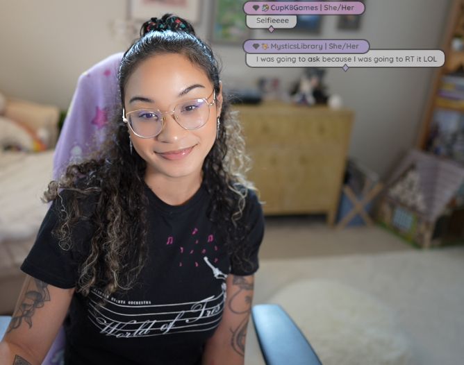 lorie wearing a kingdom hearts orchestra shirt taking a selfie with her office in the background