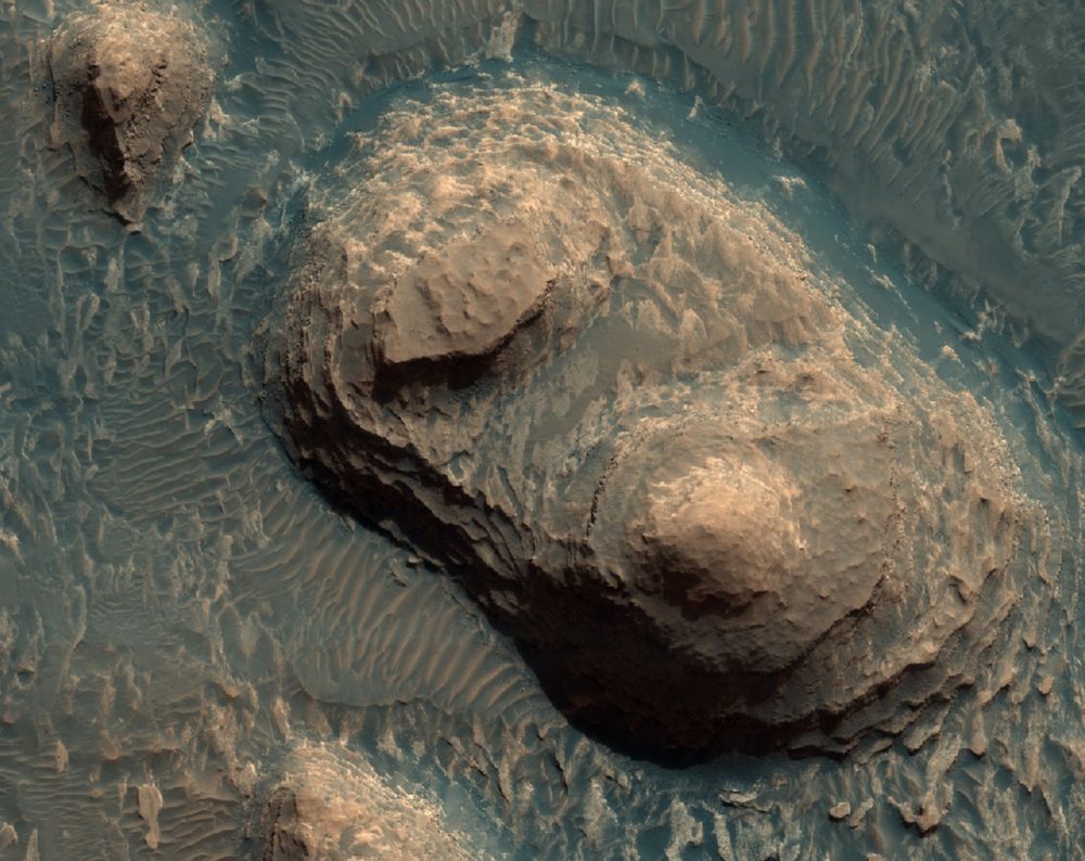 Mesas of layered rock, surrounded by dunes, seen from above. Credit: NASA/JPL-Caltech/UArizona