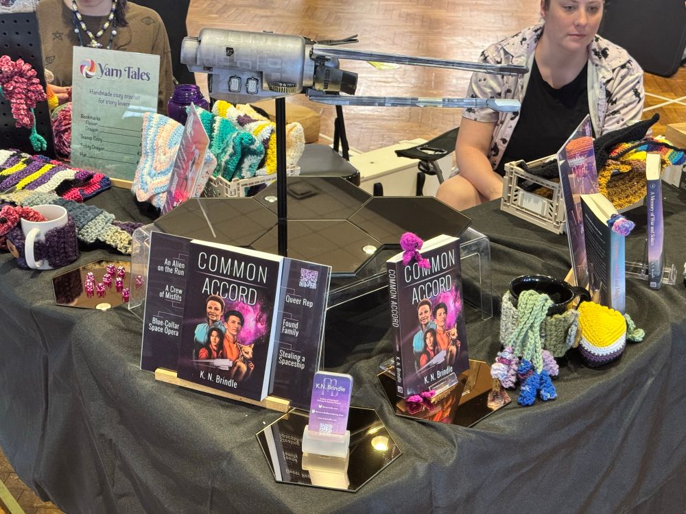 A photo of sales table with books, crochet and other goodies 