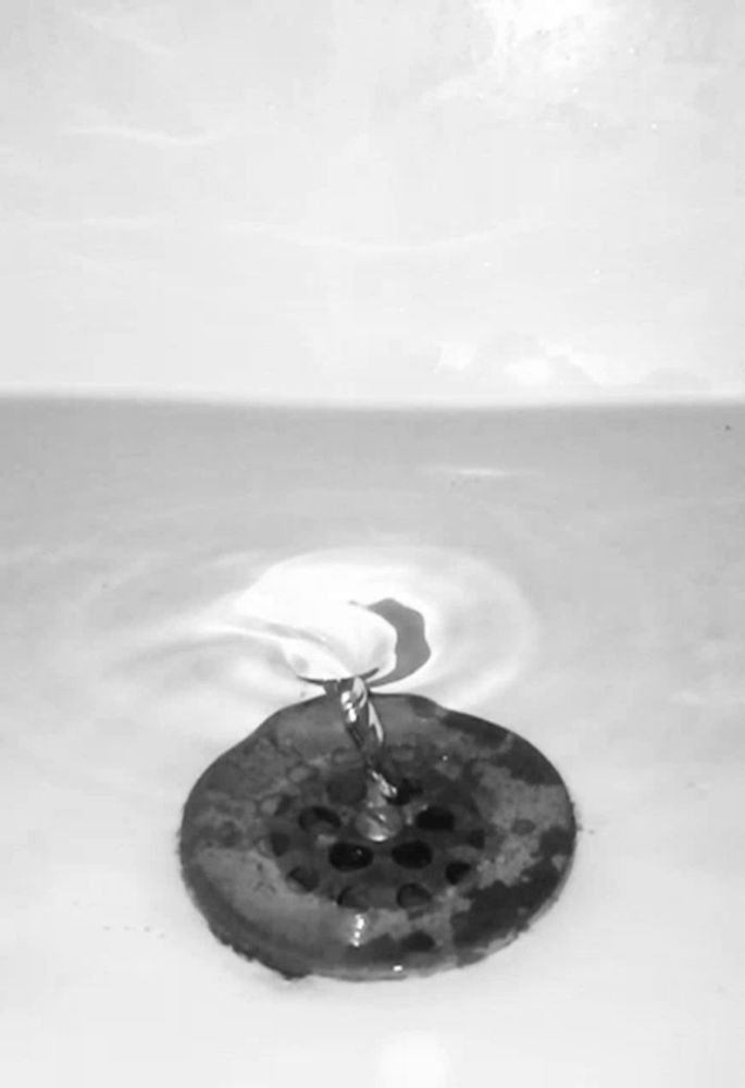 a black and white photo of a bathroom sink drain