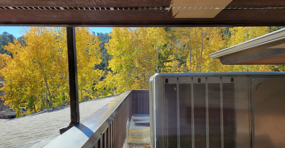 Glowing yellow aspen seen from a flat roof supporting a large hvac unit