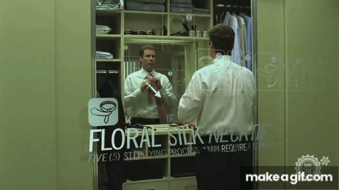 A movie scene of Will Farrell tying his pink necktie in his bathroom mirror, with little equations and quotes from the narrator appearing around him in the air.  Scene from Stranger Than Fiction