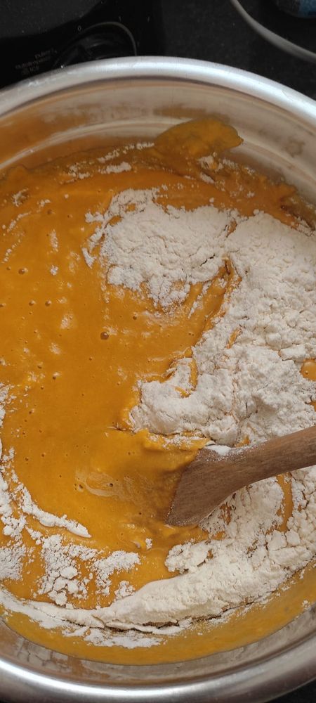 an orange batter getting mixed with flour