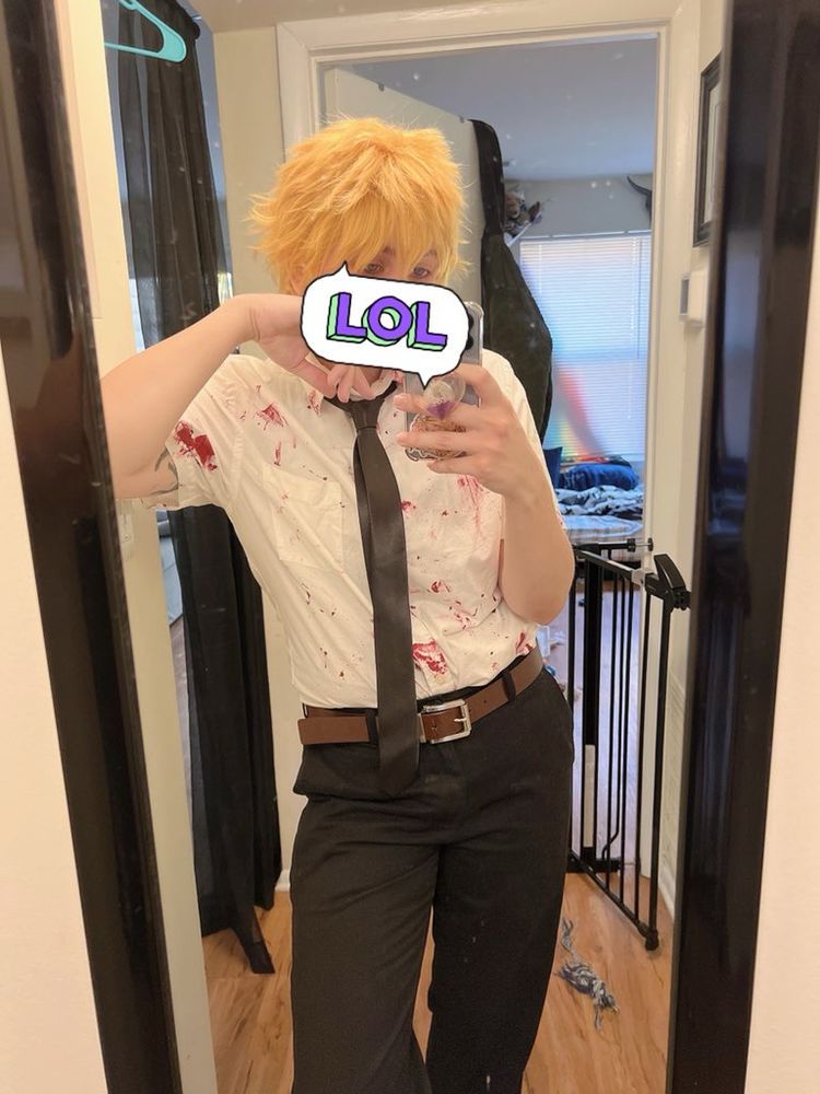 Me standing in front of a mirror wearing black slacks white button up shirt covered in blood and blonde ass wig 