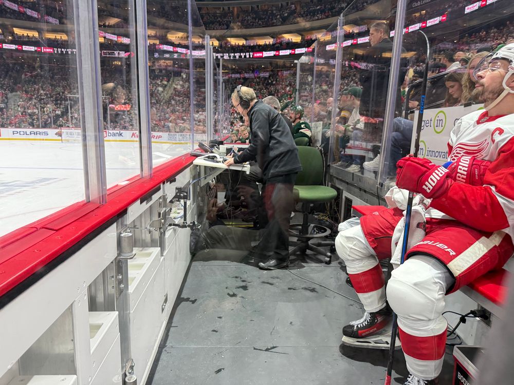 Two opposing hockey players in a penalty box 