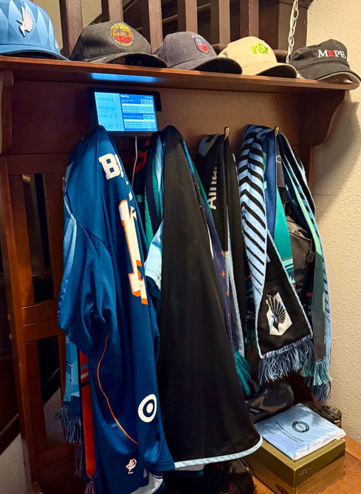A small computer display sitting on a coat rack