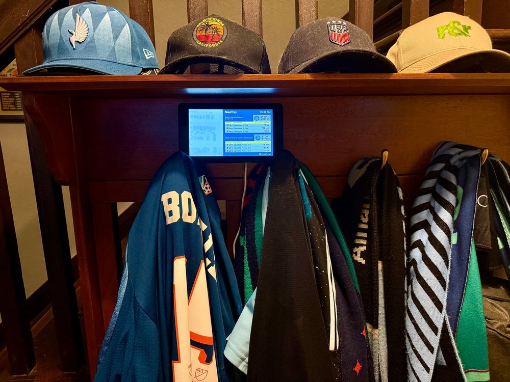 A small computer monitor sitting on a coat rack