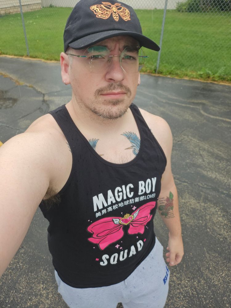 Me in a hat, tanktop, and grey sweatpants. 
