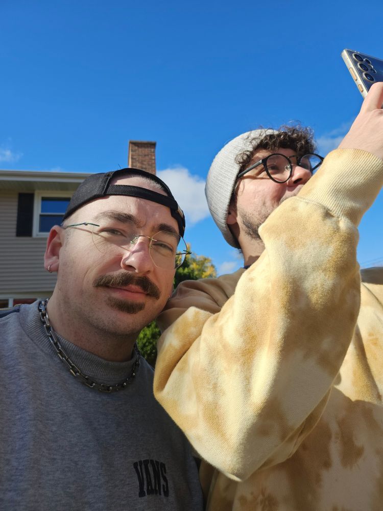 Lucas holding his phone up and taking a picture of a tree. Me standing next to him. 