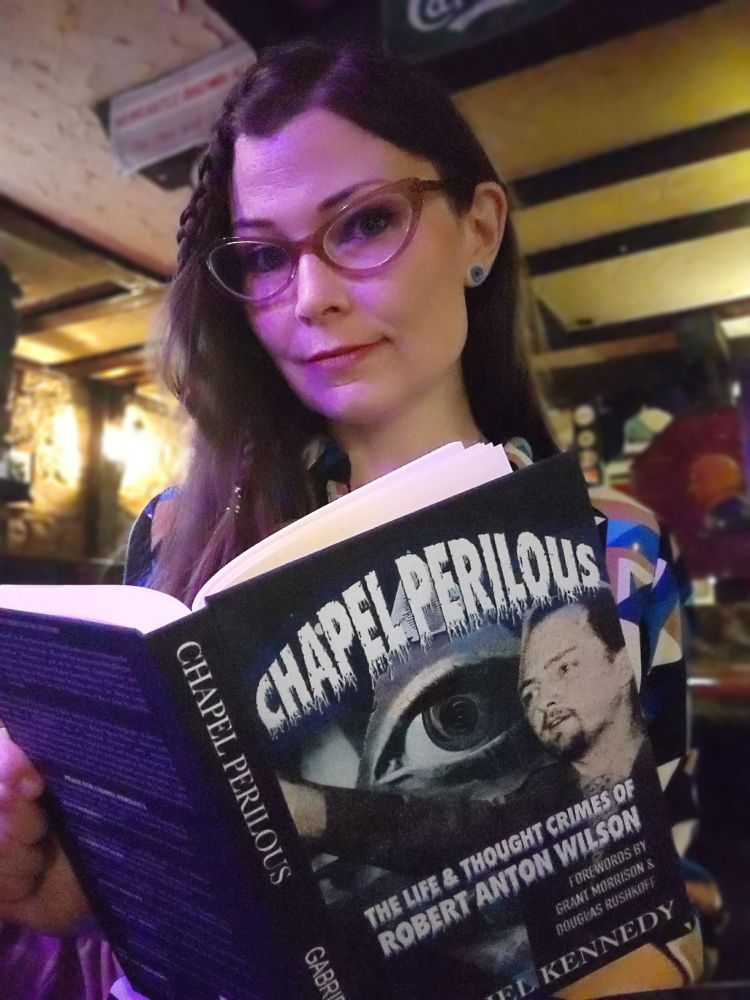Woman holding book about Robert Anton Wilson