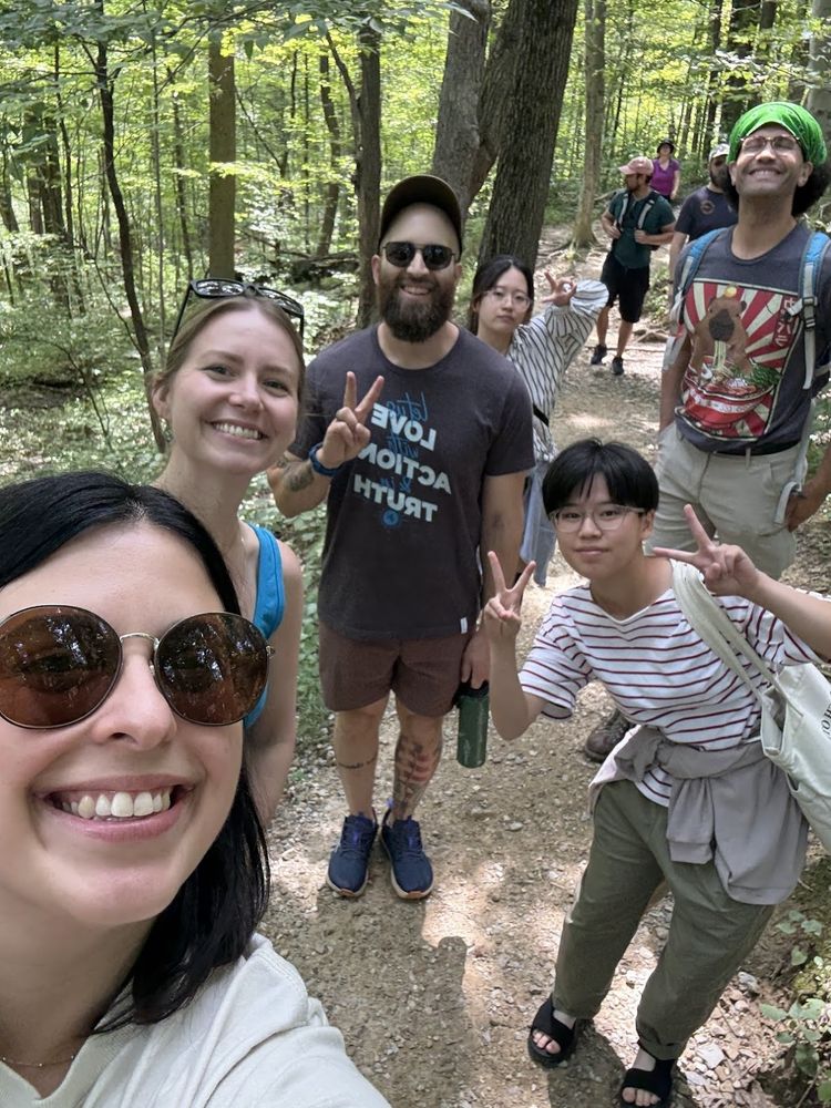 Group of six people smiling into the camera on a hike.