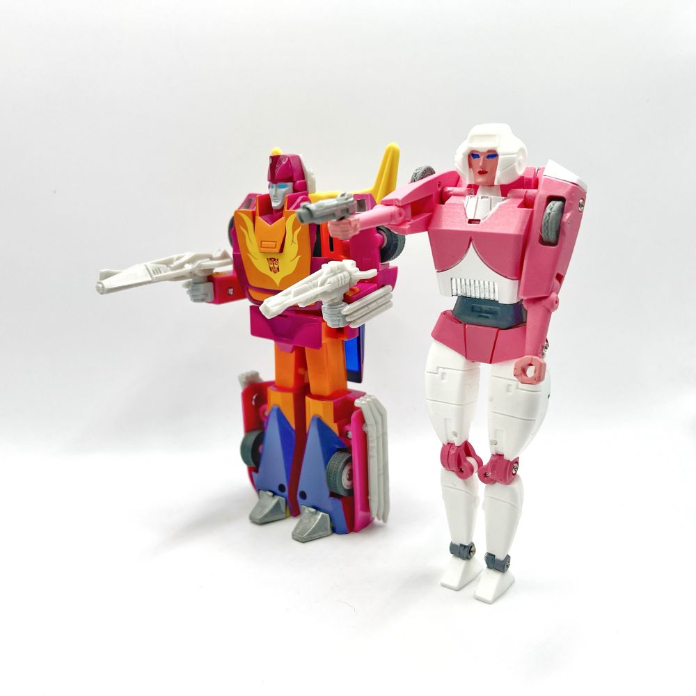 Transformers Retro Hot Rod and Carbot Darcy in their robot modes and holding their weapons 