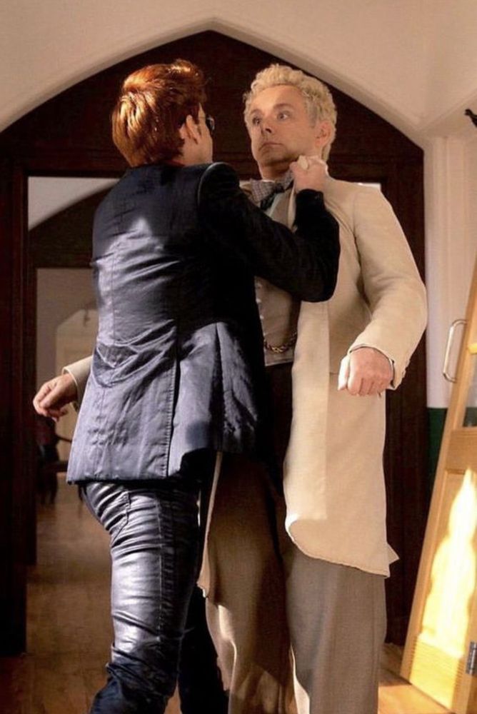 bts of the good omens wall slam, almost full body shot of crowley grabbing aziraphale’s lapels, with crowley facing away