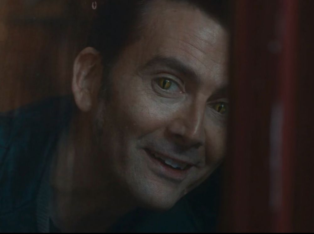 crowley looking out a window, actually smiling 
