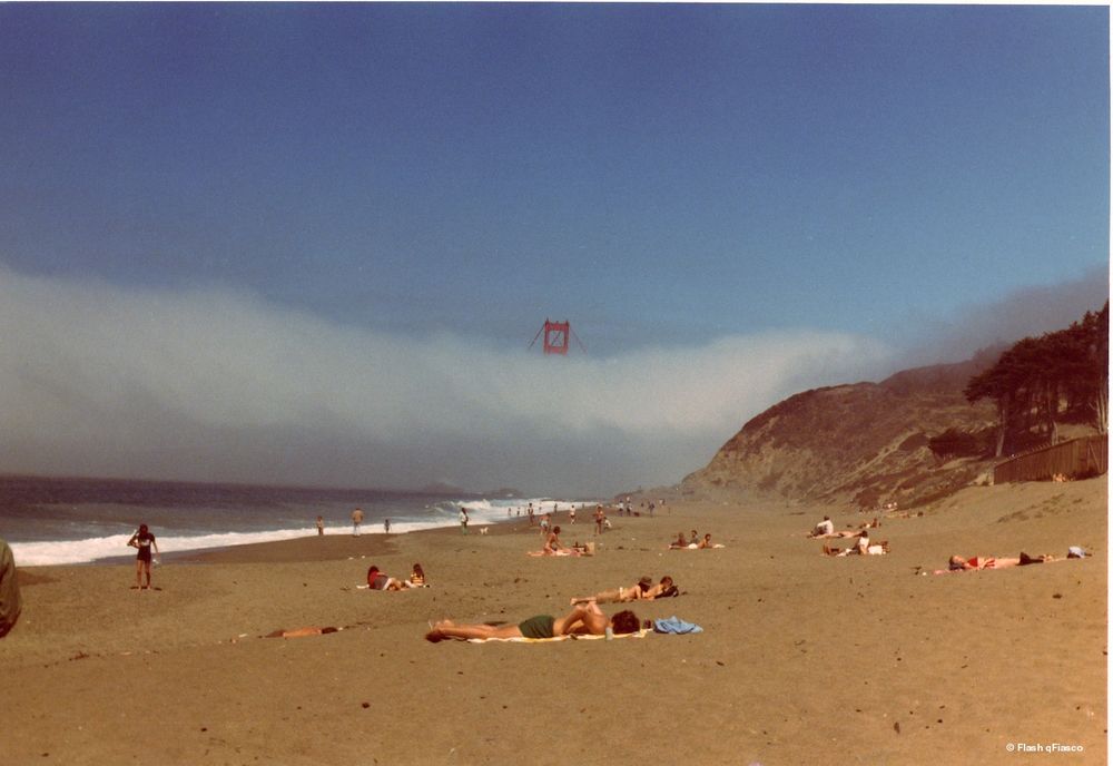 San Franciscans sunbathe on the beach as a fog bank rolls over the Golden Gate Bridge. copyright Flash qFiasco 