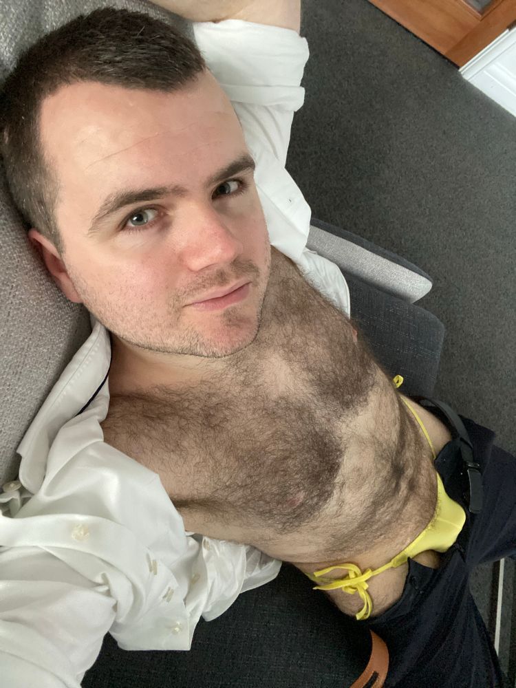 Lying on hotel sofa, shirt open showing hairy body. Trousers down showing tie yellow briefs. 