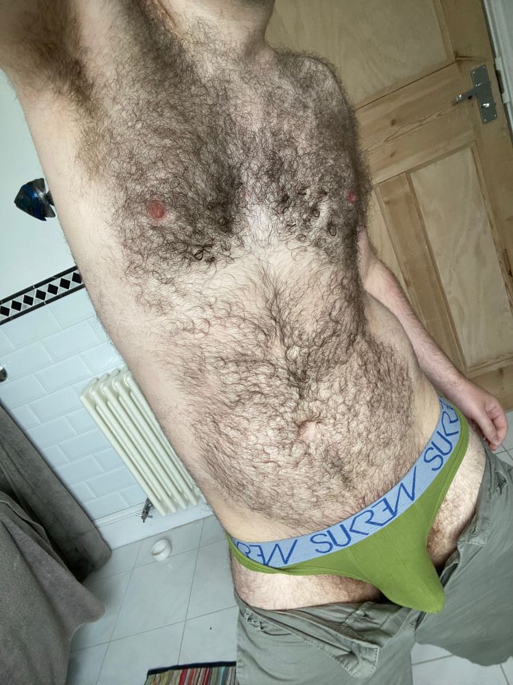 Bathroom body shot in green shorts, pulled down to show green thong. 