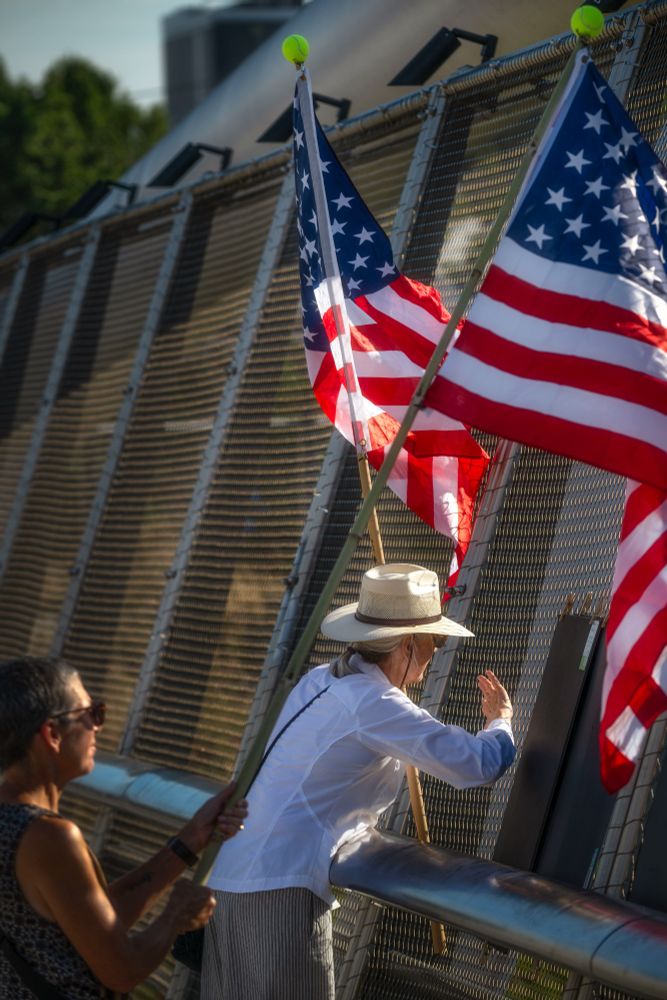 Overpass with people holding US flags, waving. Over heavy rush-hour traffic in Portland, Oregon