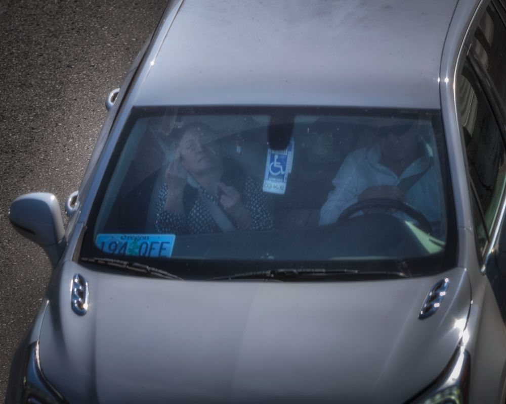 passenger in car giving the double middle finger