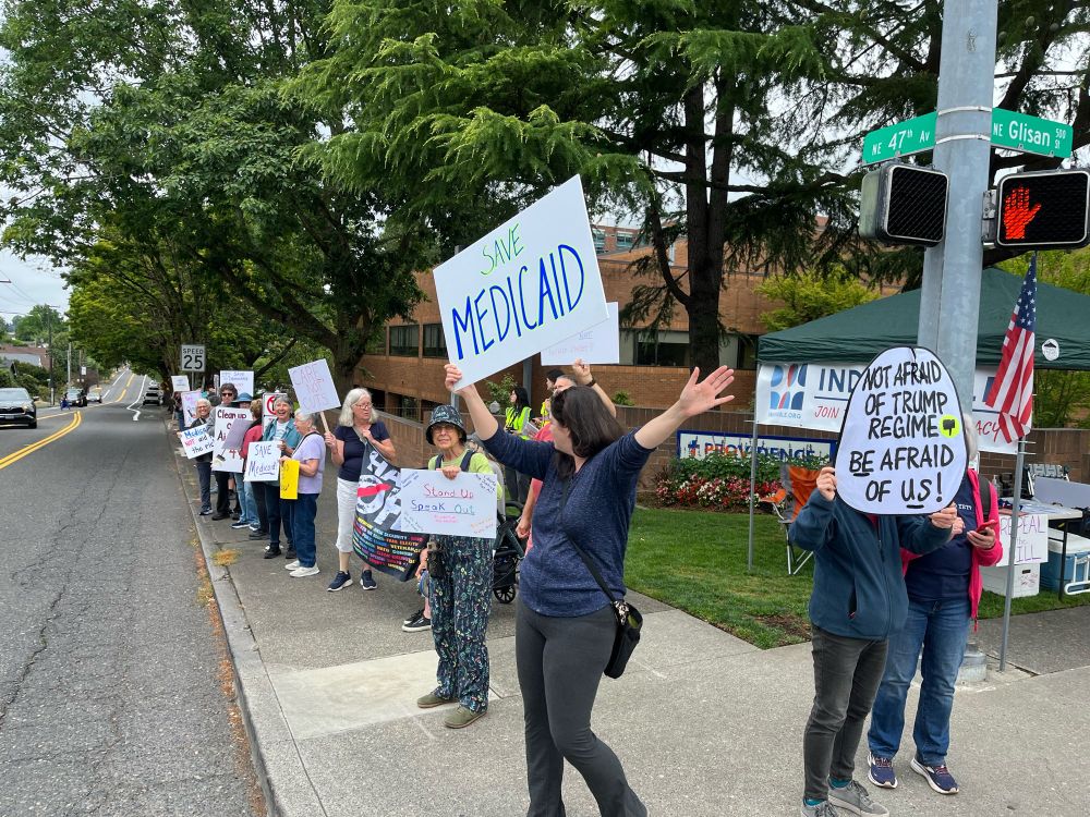 Sidewalk protesters holding signs supporting medicaid