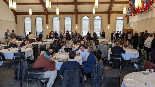 A group of faculty members are gathered in a conference room during a retreat.