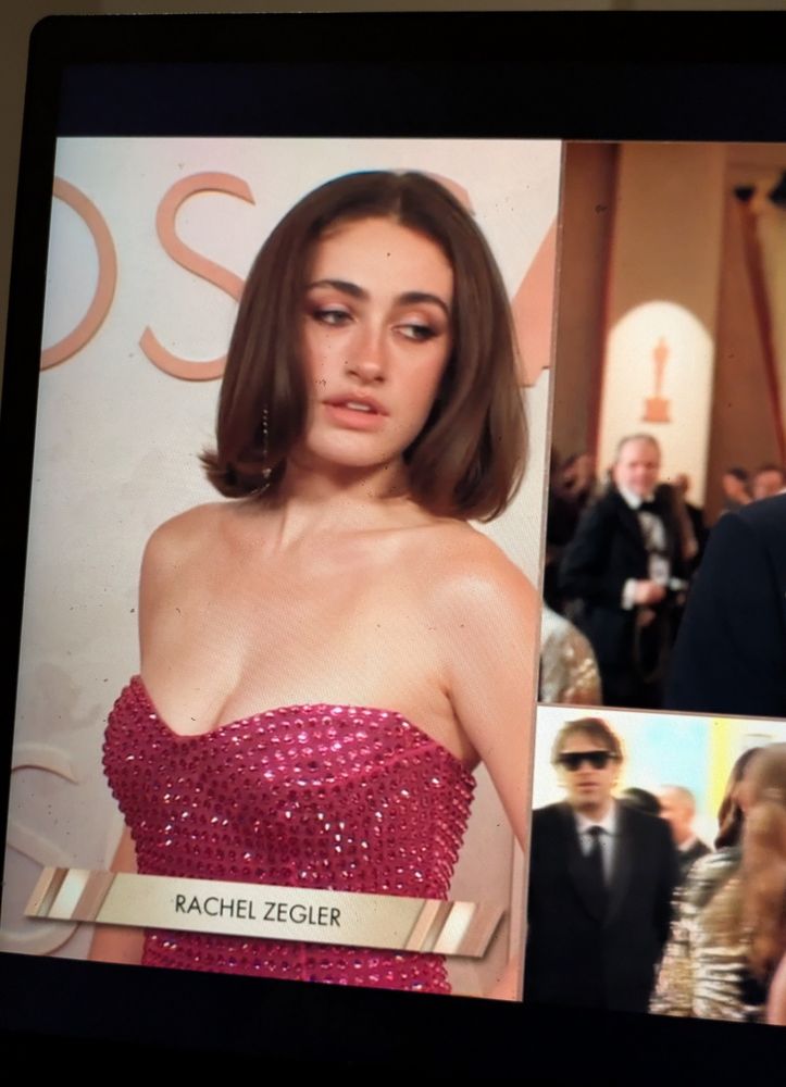 Rachel Sennott on the Oscars red carpet, but the chyron says Rachel Zegler 