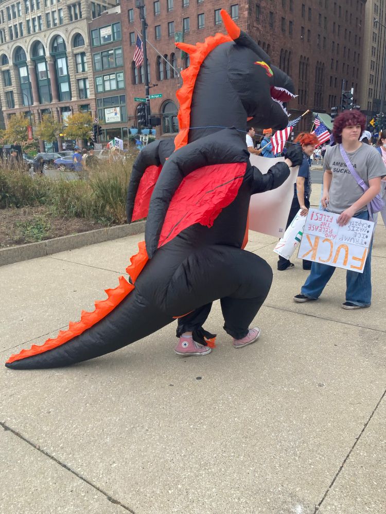 A person in an inflatable dragon costume 