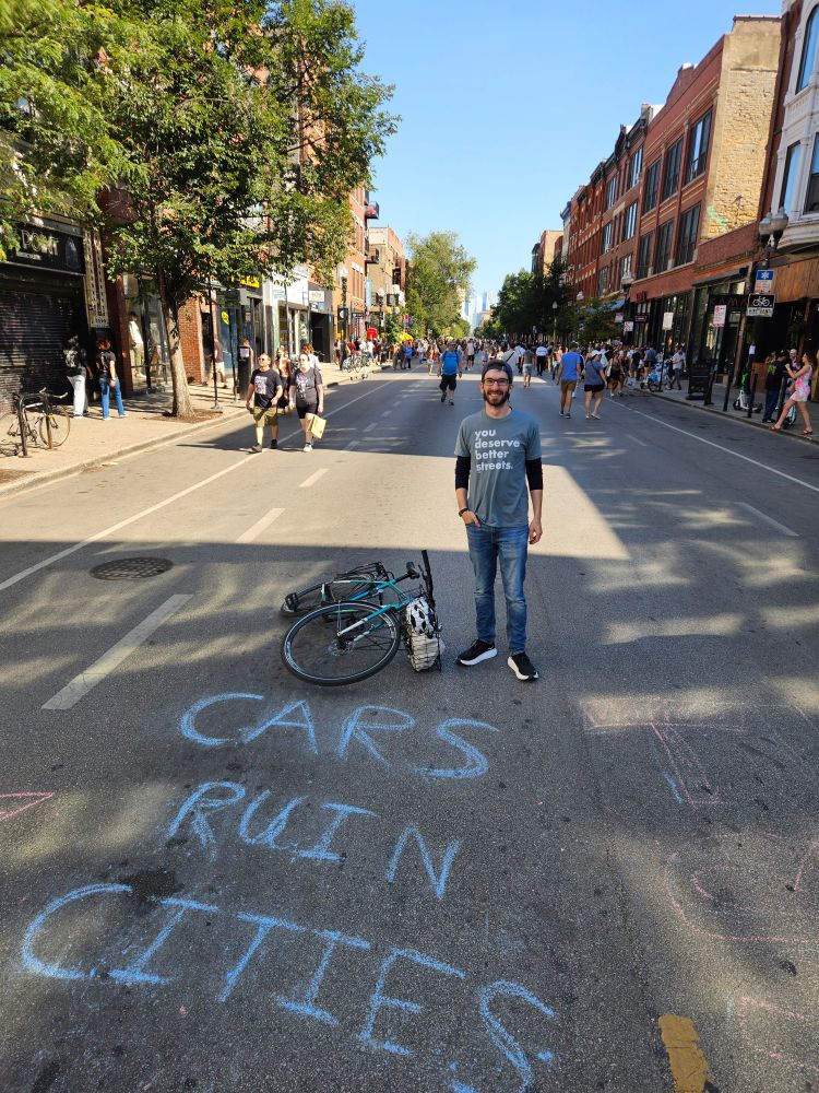 Open street. Chalk on the ground that says cars ruin cities