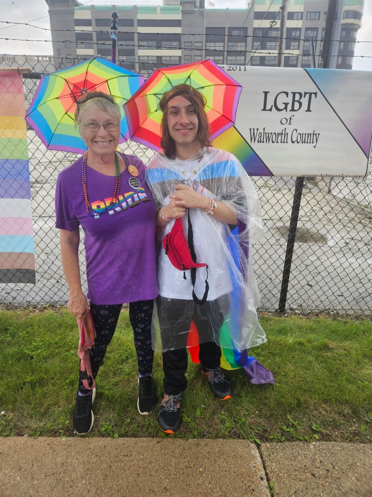 Two friends getting ready to walk in the Milwaukeee Pride Parade in their rainbow regalia.