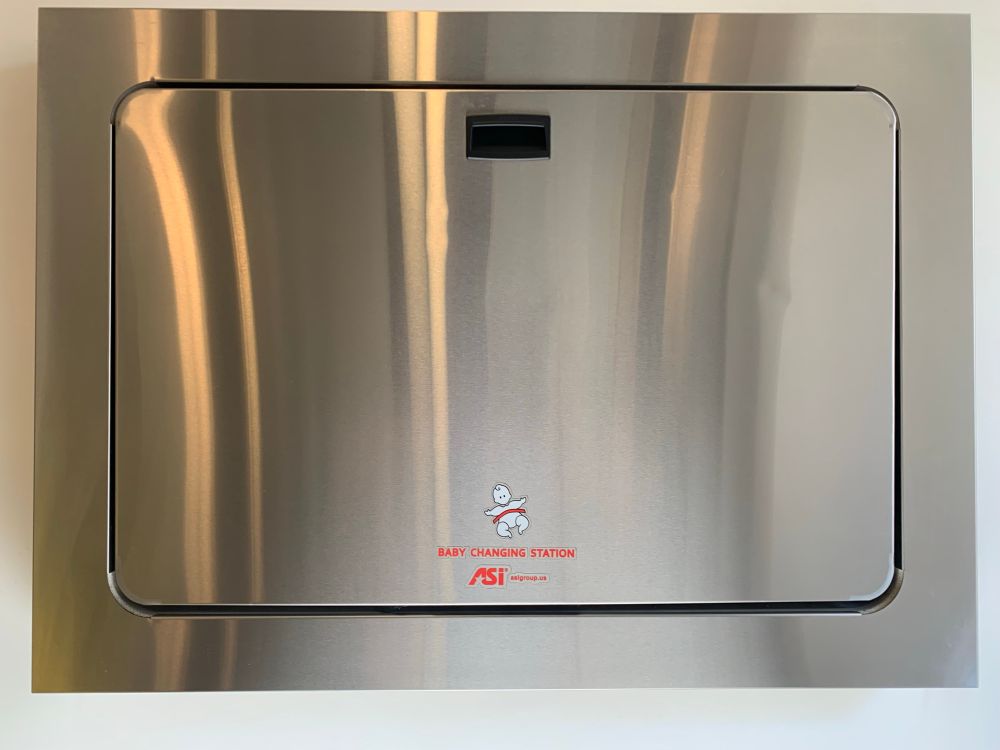 stainless steel oven-looking door with a handle at the top and the words "baby changing station" at the bottom