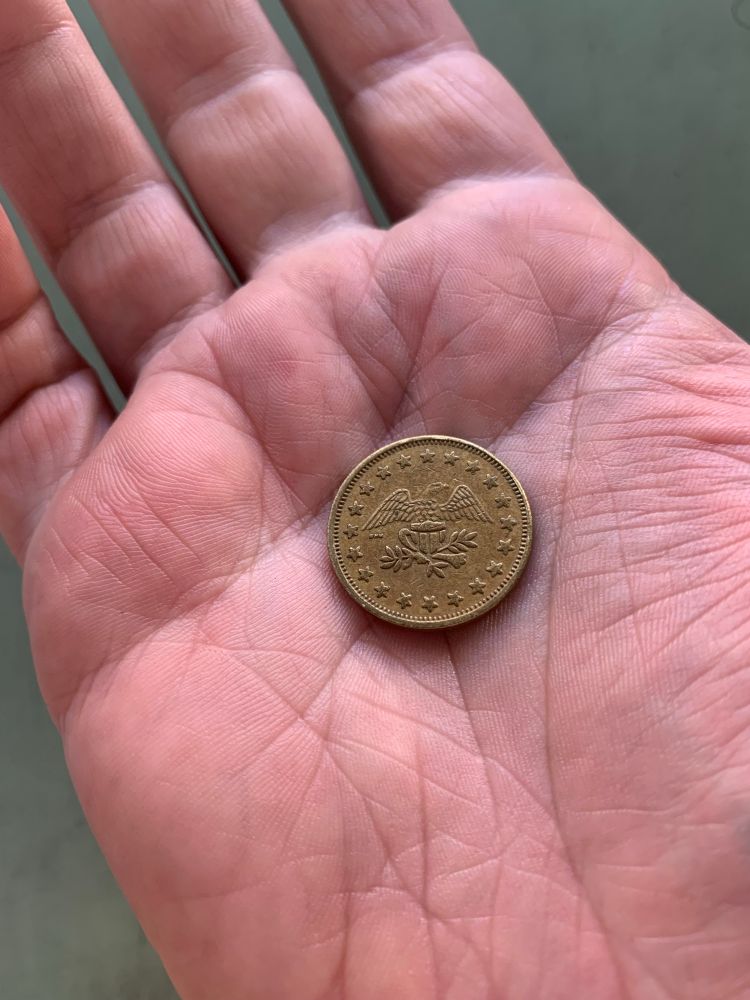 An adorable copper coin with stars and an eagle in an open, sad, middle-aged palm. 