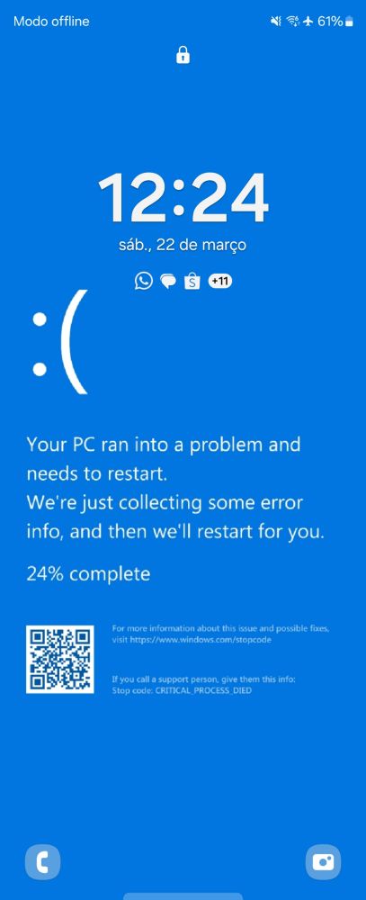 A imagem reproduiz uma tela de bloqueio de celular reproduzindo a tela de erro do windows com o fundo azul e uma mensagem em inglês dizendo que o PC entrou um erro e precisa reiniciar.